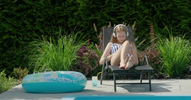 Una Adolescente Está Descansando Una Tumbona Junto Piscina Utiliza Teléfono — Vídeo de stock