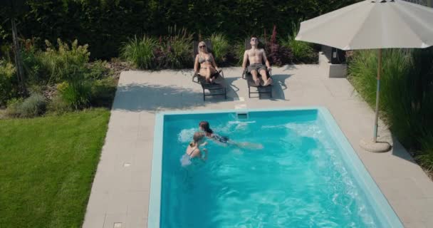 Familie Ontspant Bij Hun Zwembad Achtertuin Van Het Huis Volwassenen — Stockvideo