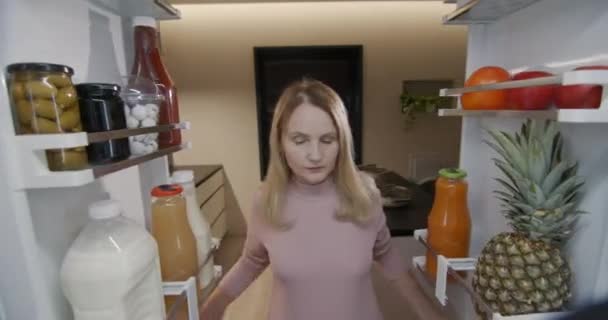 매력적인 여성은 냉장고에서 음식을 섭취합니다 냉장고 안쪽에서 비디오 — 비디오