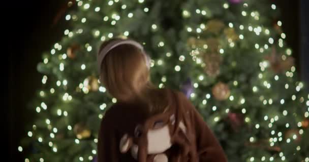 Bakifrån Ett Barn Rådjursdräkt Dansar Nära Vacker Julgran — Stockvideo