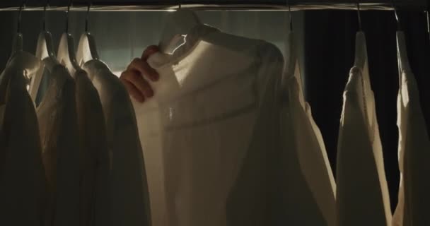 女人在更衣室里选择衣服 阳光下的轮廓 — 图库视频影像