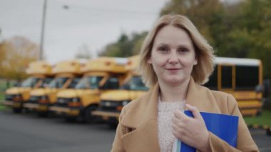 Portrait of a woman teacher on the background of the school building.