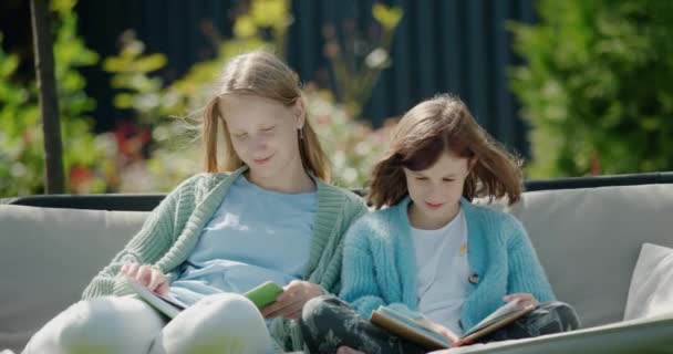 Dos Chicas Leen Libros Sientan Columpio Jardín Patio Trasero Casa — Vídeos de Stock