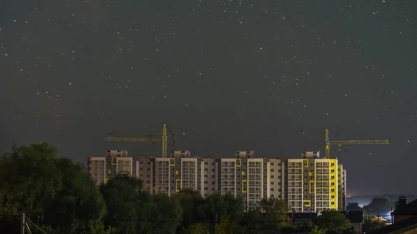 Silhuett Ett Flervåningshus Det Finns Stjärnhimmel Ovanför Honom Tranor Syns — Stockfoto
