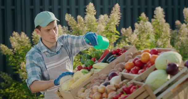 卖家把蔬菜洒在柜台上用水 农民市场上的贸易 — 图库视频影像
