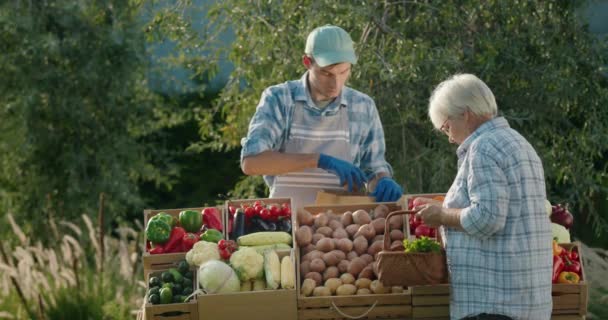 Uma Mulher Idosa Compra Legumes Mercado Agricultores Vendedor Coloca Vegetais — Vídeo de Stock