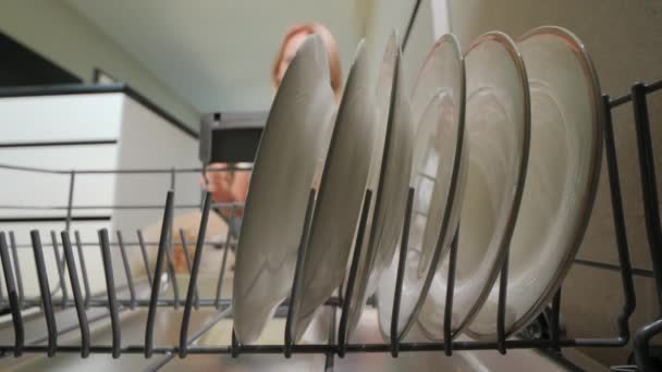 Μια Νεαρή Γυναίκα Παίρνει Καθαρά Πιάτα Από Πλυντήριο Πιάτων Κουτάβι — Αρχείο Βίντεο
