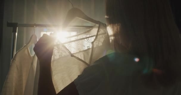 Een Vrouw Kiest Kleren Kleedkamer Silhouet Zon Achteraanzicht — Stockvideo