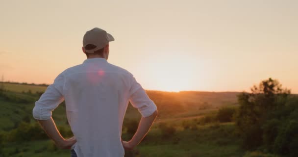 Güneş Batarken Yakışıklı Genç Bir Çiftçi Manzaralı Bir Kırsalın Önünde — Stok video