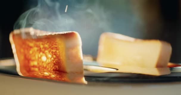 トースターから2個のバター付きカラトンが飛び出し 熱いパンから蒸気を発します 窓からの太陽が食べ物を美しく照らします スローモーション4Kビデオ — ストック動画