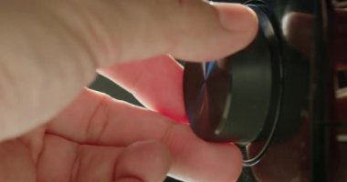 Bir adamın eli ses seviyesini ayarlar, alıcının düğmesini çevirir..