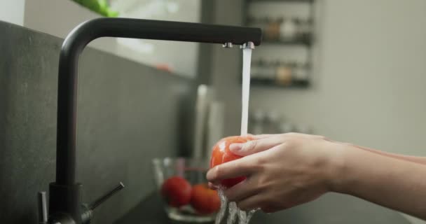 Kvinnors Händer Tvättar Mogen Röd Tomat Vattenstrålar Från Köksblandaren — Stockvideo