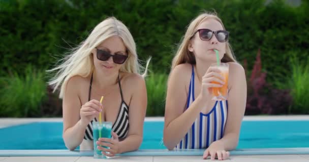 妈妈和十几岁的女儿在游泳池边放松一下 喝着鸡尾酒 — 图库视频影像