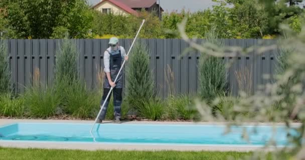 労働者は特別な掃除機が付いているプールをきれいにする — ストック動画