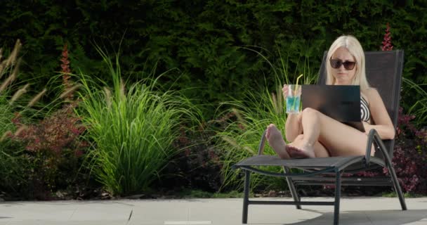 Una Mujer Joven Traje Baño Está Relajando Una Tumbona Utilizando — Vídeo de stock