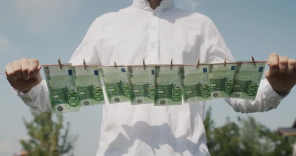 Man Holds Clothesline His Hands Which Banknotes Hang Money Laundering — Video
