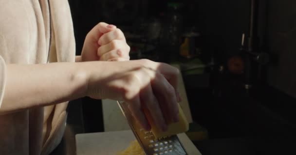 当一个女人在烤架上烤奶酪时 窗外的阳光照在她的手上 — 图库视频影像