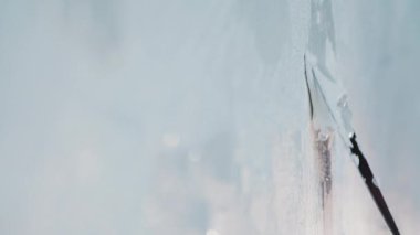 Mimarilerin eli macun bıçağıyla, beyaz bir duvarda macunla..