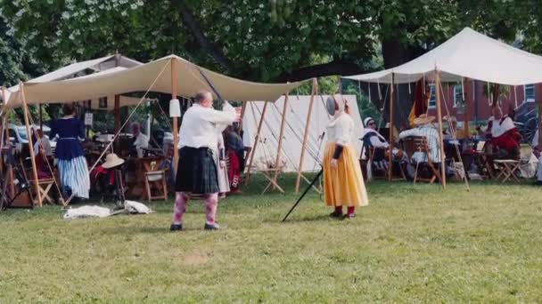 热火朝天的人们在18世纪美国军队帐篷营的背景下排练剑战 — 图库视频影像