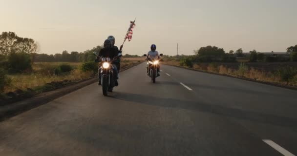 バイクのシルエット アメリカの旗と日没でハイウェイに乗る — ストック動画