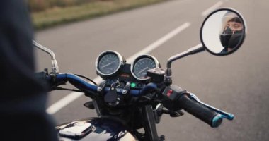 Motosikletlilerin elleri direksiyonda gaz pedalını çevirir..