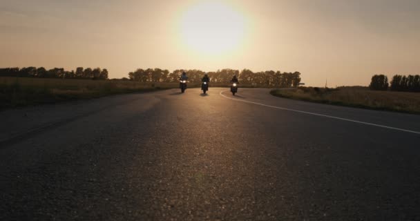 Tre Motociclisti Guidano Lungo Autostrada Davanti Alla Telecamera Tramonto — Video Stock