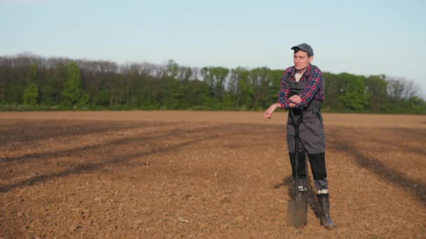 Portret Młodego Rolnika Stojącego Zaoranym Polu Opierającego Się Łopatę — Wideo stockowe