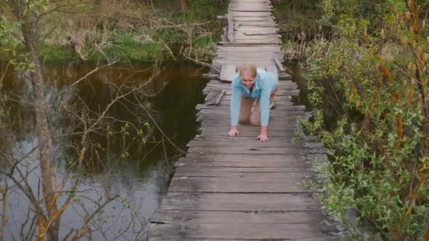 Una Mujer Arrastra Través Desvencijado Puente Colgante Tiene Miedo Irse — Vídeo de stock