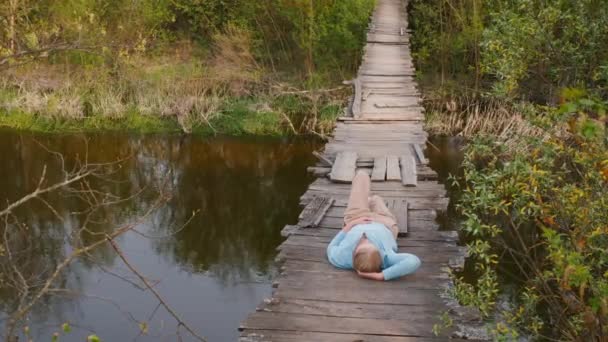 Une Femme Détend Sur Fragile Pont Suspendu Enjambant Une Rivière — Video