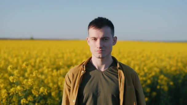 Portretul Unui Tânăr Fermier Încrezător Fundalul Unui Câmp Rapiță Înflorit — Videoclip de stoc
