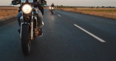 Bir grup motorcu düz bir otoyolda gidiyor, tekerleklerin altında parlayan yolları işaretliyorlar. Özgürlük ve Seyahat Konsepti.