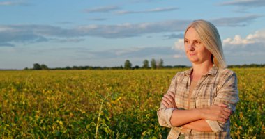 Orta yaşlı bir çiftçi kadın gün batımında yemyeşil bir tarlanın ortasında güven içinde duruyor. Uzağa dikkatlice bakarken kolları çapraz. Sıkı çalışmayı ve bağlılığı temsil ediyor.