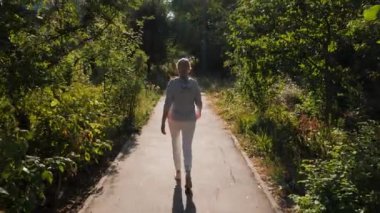 Orta yaşlı bir kadın sabahın erken saatlerinde park yolunda yürür. Yeni doğan güneş arkasında uzun bir gölge bırakıyor, barışçıl ve yansıtıcı bir atmosfer yaratıyor. Huzur parkı ayarları