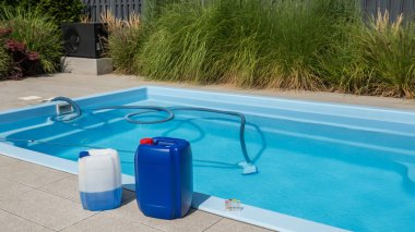 A poolside view features two large containers of pool chemicals alongside a pool equipped with a cleaning hose submerged in the water. A water testing kit is also visible on the pool edge, emphasizing clipart