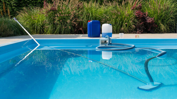 На изображении виден прозрачный голубой бассейн с моющим шлангом, погруженным в воду. Контейнеры с водой и комплект для тестирования расположены на берегу бассейна, что позволяет сосредоточить внимание на