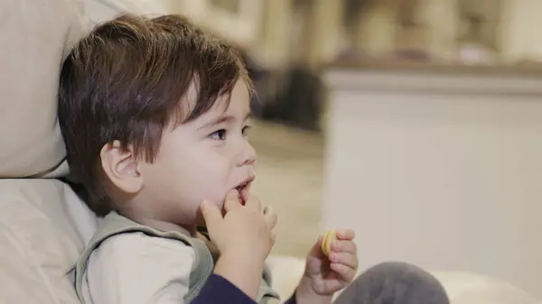 stock image A two-year-old eats crackers. Unhealthy junk food harmful to health.