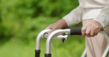 Aylağı zarif bir şekilde kullanan yaşlı bir insan yemyeşil bir açık hava ortamında hareket ediyor.