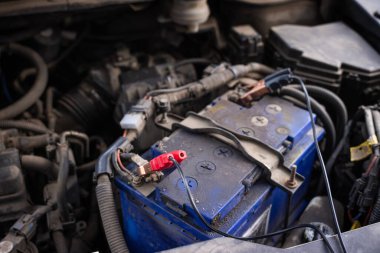 Bağlantı kablosu olan bir araba aküsünün yakın çekim görüntüsü, araç bakım ve onarım çalışmaları devam ediyor. Yüksek kalite fotoğraf