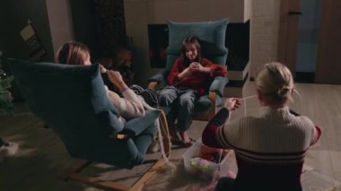 Şöminenin yanında örgü ören bir aile, samimi ve şenlikli bir atmosferi olan, ortak bir yaratıcı aktivite ile bağ kuran bir aile. Yüksek kalite 4k görüntü