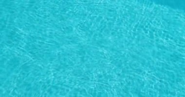 Işıldayan dalgalar ve ışık yansımaları ile berrak mavi havuz suyu, dokular ve arka planlar için mükemmel. Yüksek kalite 4k görüntü