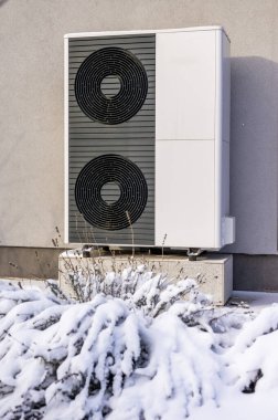 Kışın bir evin dışında modern ısı pompası ünitesi soğuk havada enerji tasarruflu ısıtma sağlıyor. Yüksek kalite fotoğraf