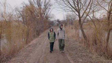 Genç bir çift, bulutlu bir bahar gününde göl kenarında kirli bir patika boyunca el ele yürür. Uzun kamışlarla ve çıplak ağaçlarla çevrili kalın giysiler giyiyorlar. Düşüncelere dalmışlar. Yüksek