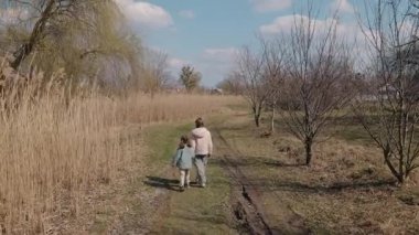 Parlak bir bahar gününde, kırsal alanda çimenli bir yolda yürüyen iki genç kız, göl kenarında huzur içinde vakit geçiriyorlar. Yüksek kalite 4k görüntü