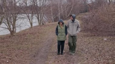 Genç bir çift bulutlu bir bahar gününde göl kenarında kirli bir patika boyunca yürür. Kapüşonlu kalın ceketler giyiyorlar, ağaçların ve yaprakların arasında sessizce hareket ediyorlar, düşüncelere dalmışlar. Yüksek