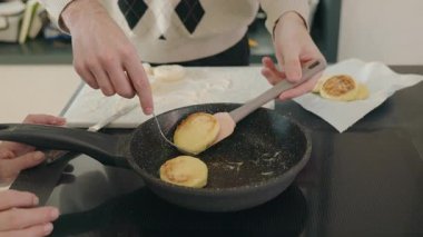 Erkek ellerinin ev yemeği yaparken spatula ve çatal kullanarak şurubu kızartma tavasında çevirdiği yakın çekim. Yüksek kalite 4k görüntü