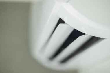 Beyaz klima hoparlörleri kapalı alanda, minimalist arka plana sahip modern bir klima kontrol sisteminde havalandırma yüzgeçlerini gösteriyor. Yüksek kalite fotoğraf