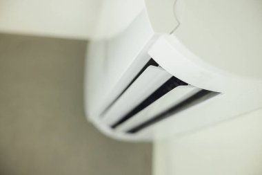 Modern bir iç mekanda açık hoparlörlü duvara monte edilmiş klima, hassas hava akışı kontrolü için tasarlanmış ünitelerin yakın çekimini gösteriyor. Yüksek kalite fotoğraf