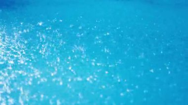 Gün ışığında sağanak yağış sırasında yağmur damlalarının mavi yüzme havuzuna çarpması. Yüksek kalite 4k görüntü