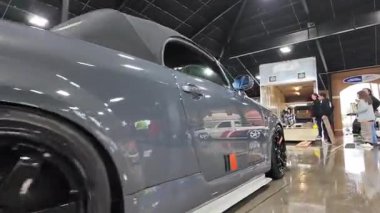 Beyaz takım elbiseli, arabalı bir adam.