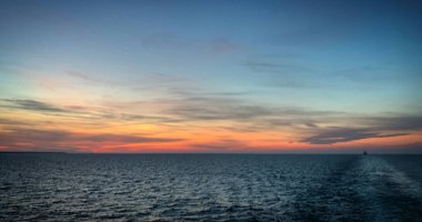 Baltık Denizi 'nin üzerinde renkli bir gökyüzü olan güzel gün batımı feribottan Tallinn, Estonya, Ağustos 2019' a giderken görülüyor.